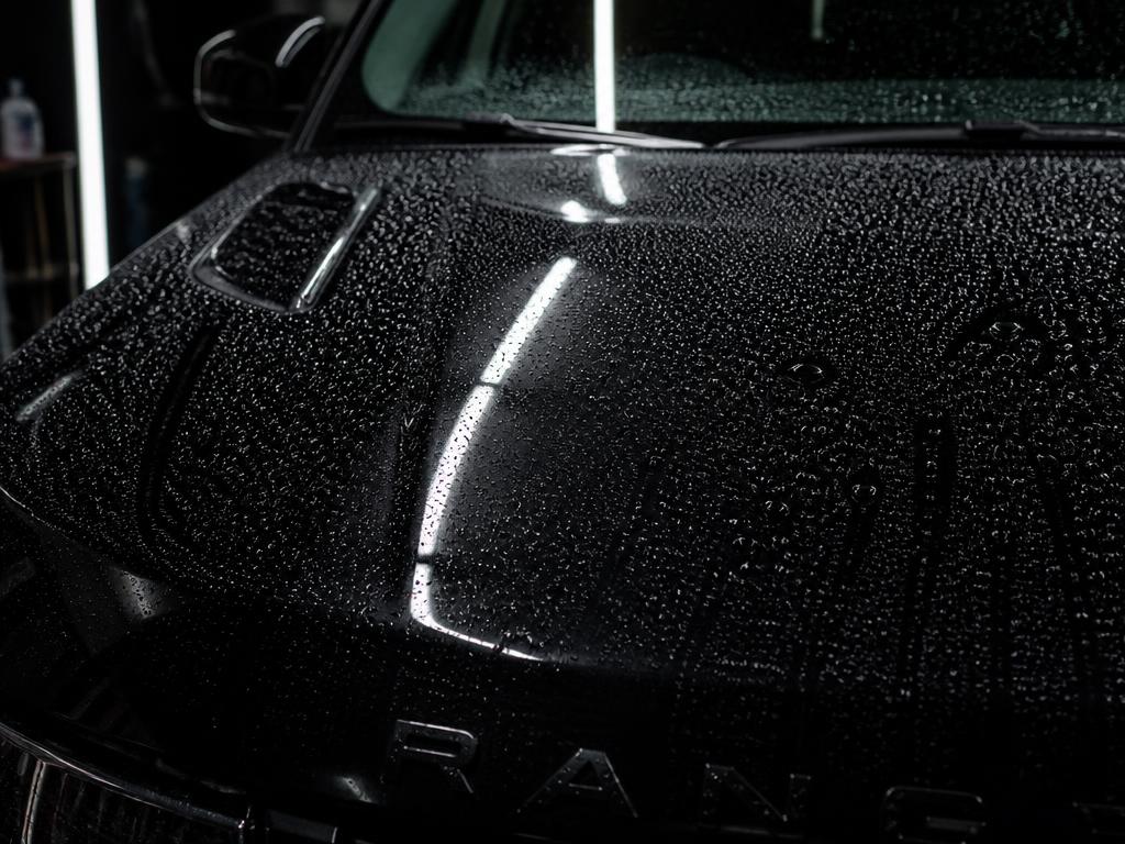 Glossy black SUV hood with water beading after an AutoGlow detail